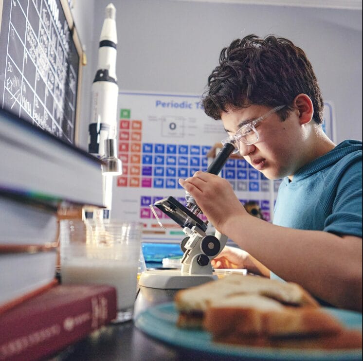 child looking through a microscope