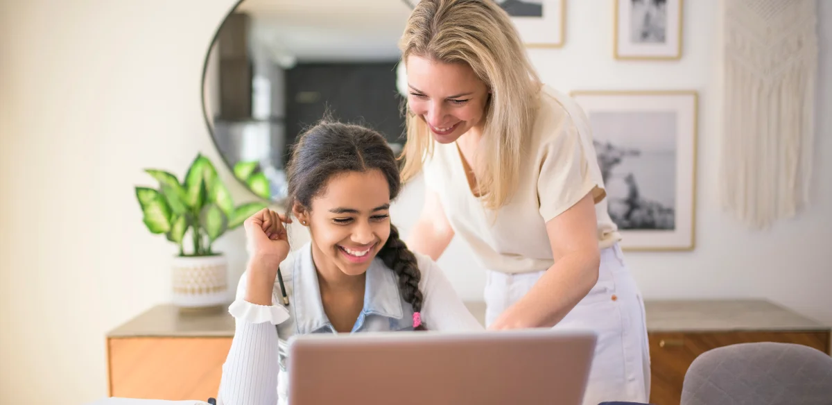 Mother and daughter working with their laptop together